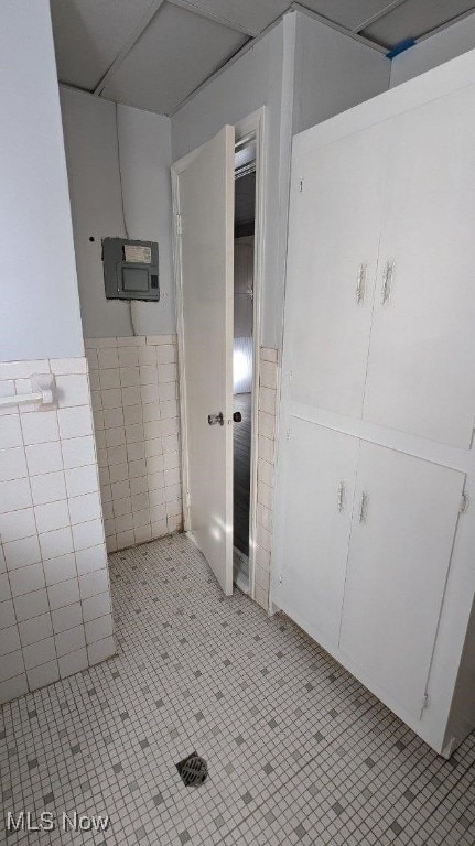 bathroom featuring tile patterned flooring and tile walls