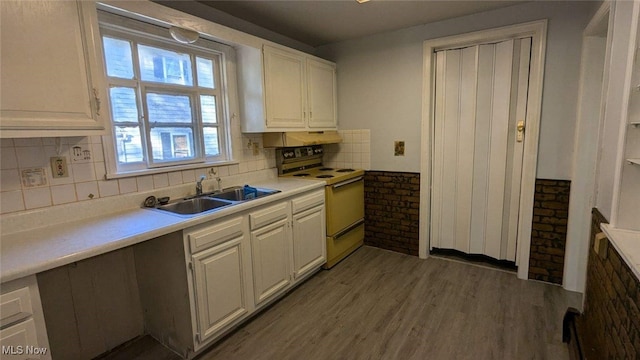 kitchen featuring electric range, tasteful backsplash, white cabinetry, and sink