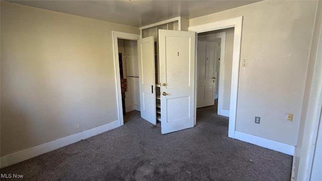 unfurnished bedroom with dark carpet