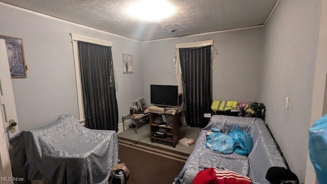 bedroom featuring a textured ceiling, crown molding, and carpet