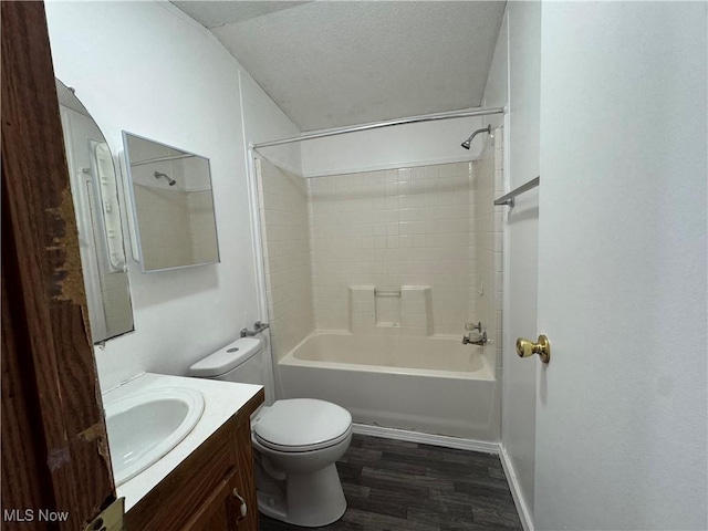 full bathroom with vanity, a textured ceiling, hardwood / wood-style flooring, toilet, and shower / washtub combination