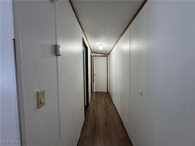 hallway featuring lofted ceiling, a textured ceiling, and hardwood / wood-style flooring