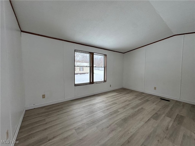 unfurnished room with vaulted ceiling and light hardwood / wood-style floors