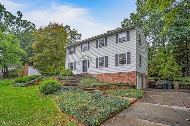 colonial-style house with a front yard and a garage