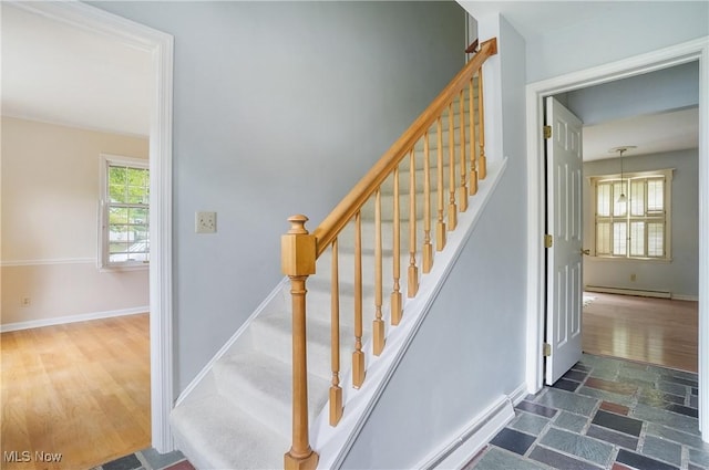 stairway featuring baseboard heating