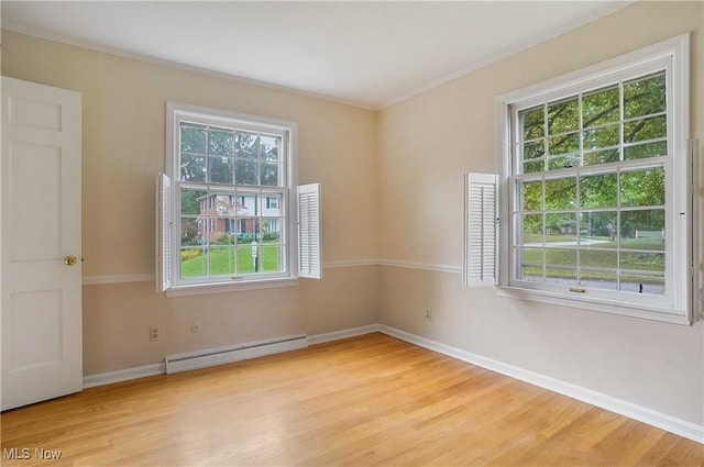 unfurnished room with light hardwood / wood-style floors, baseboard heating, plenty of natural light, and ornamental molding