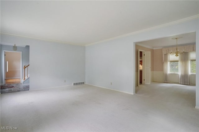 carpeted spare room featuring an inviting chandelier and ornamental molding