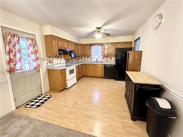 kitchen featuring light hardwood / wood-style floors, ceiling fan, decorative backsplash, black appliances, and sink