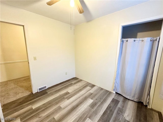 unfurnished room with ceiling fan and hardwood / wood-style flooring