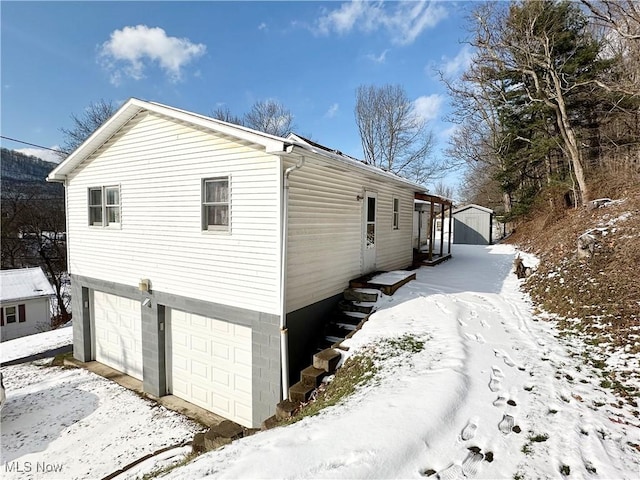 snow covered property with a garage