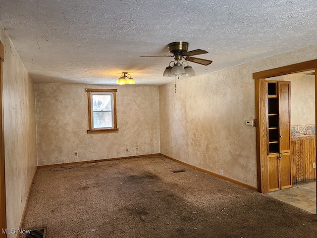 carpeted empty room featuring ceiling fan and a textured ceiling