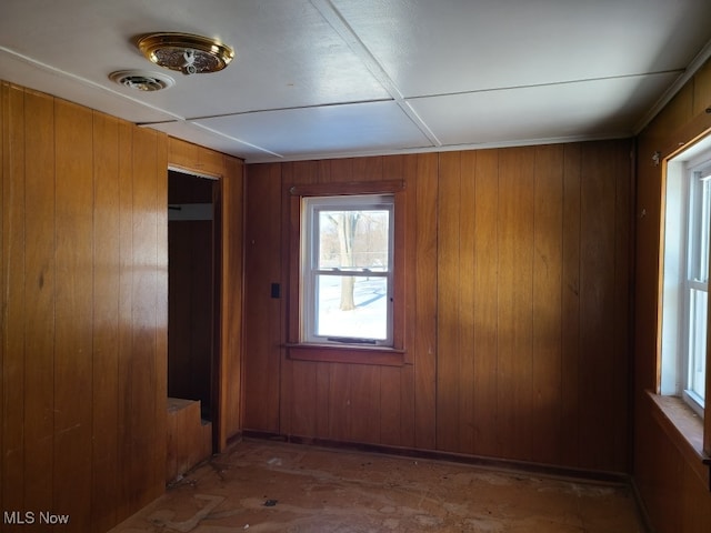 unfurnished room with wood walls