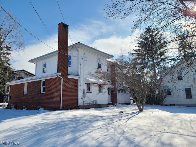 view of snow covered rear of property