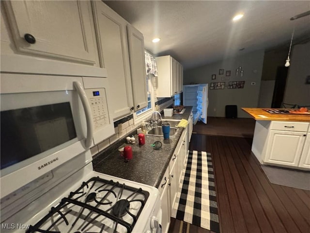 kitchen with sink, white cabinets, lofted ceiling, wooden counters, and dark hardwood / wood-style floors