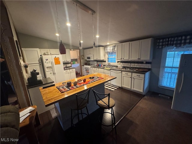 kitchen featuring butcher block counters, white appliances, white cabinetry, and tasteful backsplash