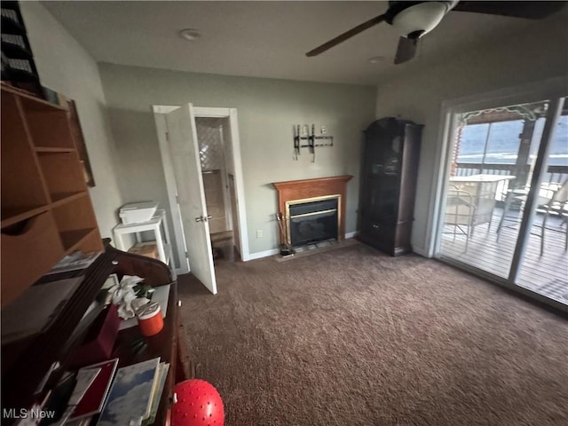 living room featuring ceiling fan and dark colored carpet