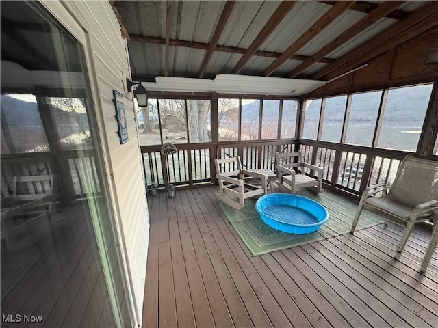 unfurnished sunroom featuring vaulted ceiling