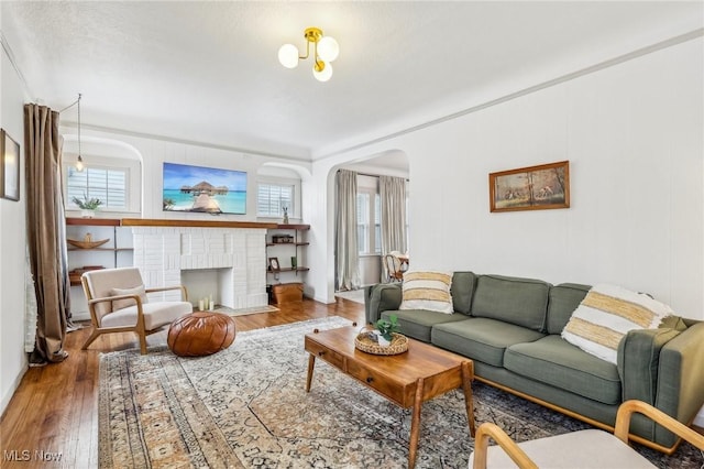 living room featuring ornamental molding, hardwood / wood-style floors, and a fireplace