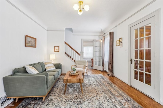 living room with ornamental molding and wood-type flooring