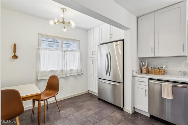 kitchen with white cabinets, appliances with stainless steel finishes, and a chandelier