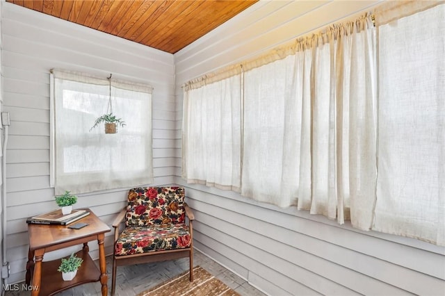 living area featuring wooden ceiling and wood walls