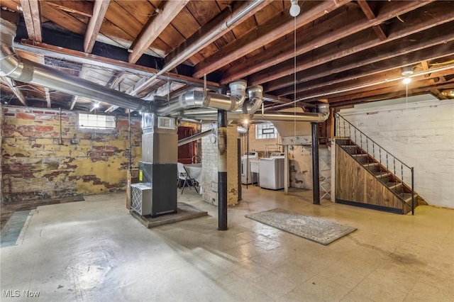 basement with washer and dryer, heating unit, and a wealth of natural light