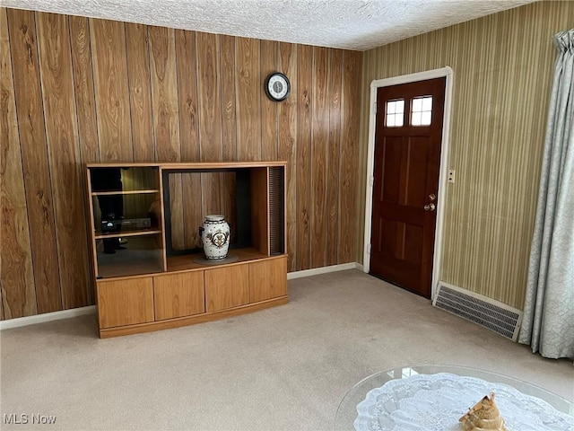 unfurnished living room featuring light colored carpet and a textured ceiling