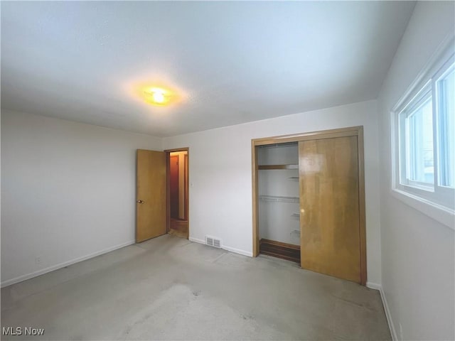 unfurnished bedroom featuring light colored carpet and a closet