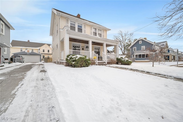 view of property featuring a porch, a garage, and an outdoor structure