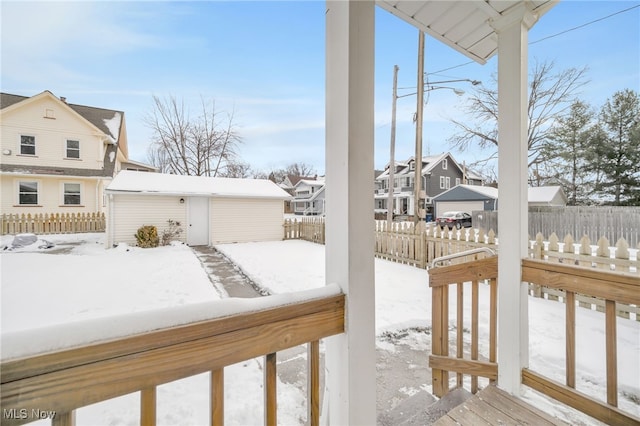 snow covered deck featuring a shed