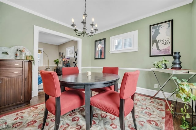 dining space featuring a chandelier, ornamental molding, and light hardwood / wood-style flooring