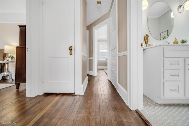 hallway featuring ornamental molding and dark hardwood / wood-style floors