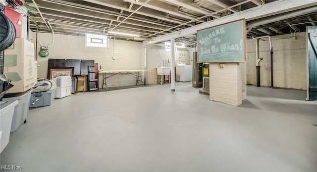 basement featuring washer and clothes dryer and sink