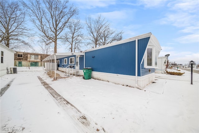 snow covered house with central AC unit