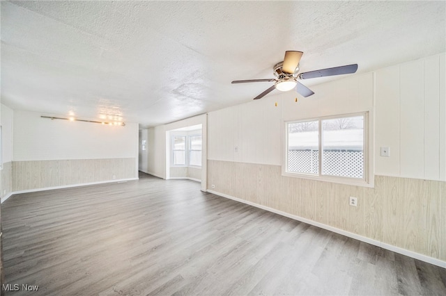 spare room featuring a textured ceiling, ceiling fan, and wood-type flooring