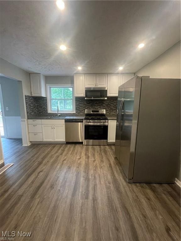 kitchen featuring sink, stainless steel appliances, white cabinetry, and dark hardwood / wood-style flooring