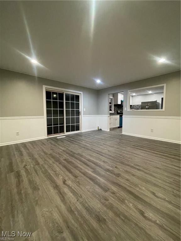 unfurnished living room with dark hardwood / wood-style flooring