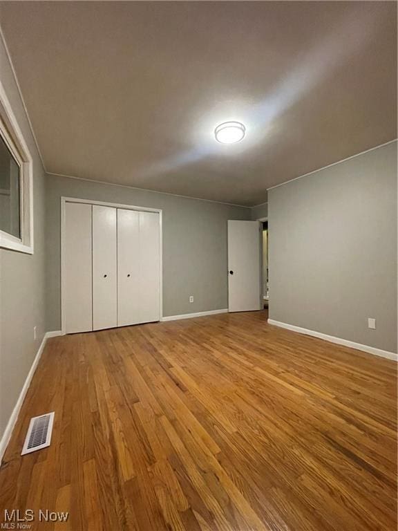 unfurnished bedroom featuring a closet and light hardwood / wood-style flooring