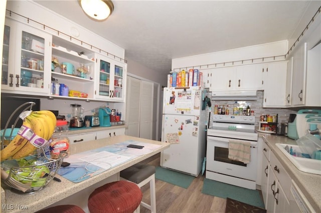 kitchen with sink, white cabinets, white appliances, light hardwood / wood-style flooring, and decorative backsplash