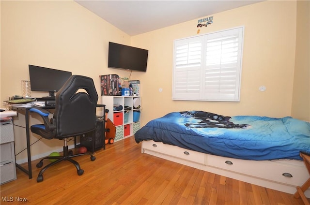 bedroom featuring lofted ceiling and light wood-type flooring