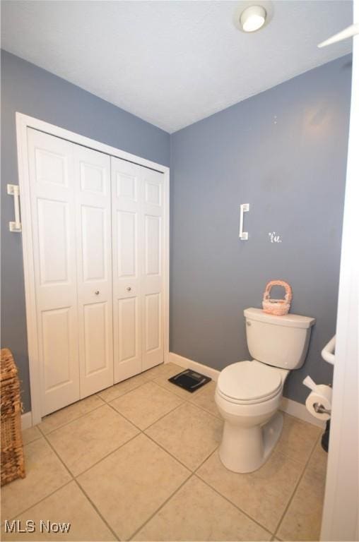 bathroom featuring toilet and tile patterned flooring