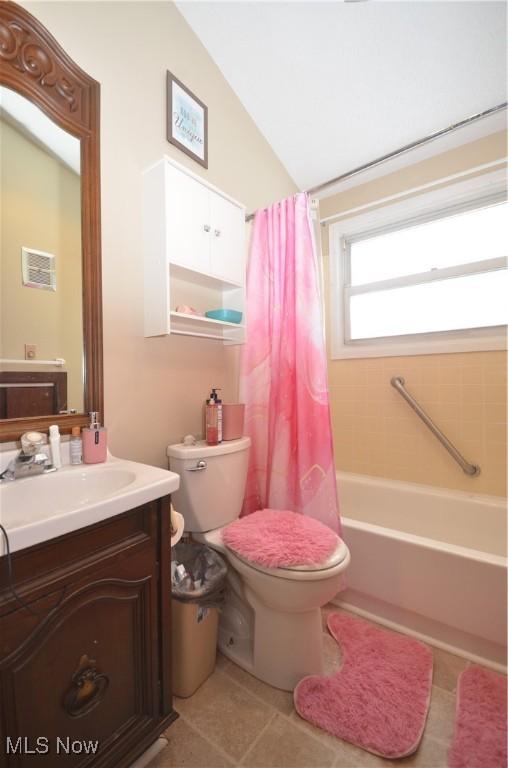 full bathroom featuring vaulted ceiling, toilet, tile patterned floors, shower / bath combo, and vanity