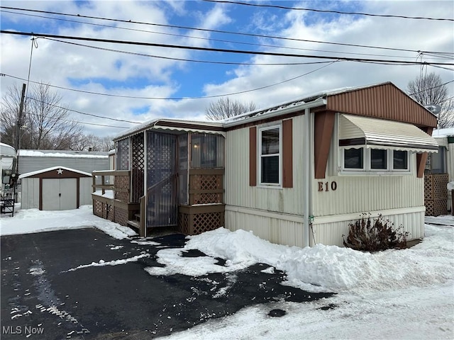 snow covered property with a shed