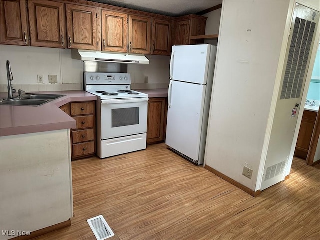 kitchen with white appliances, light hardwood / wood-style flooring, and sink