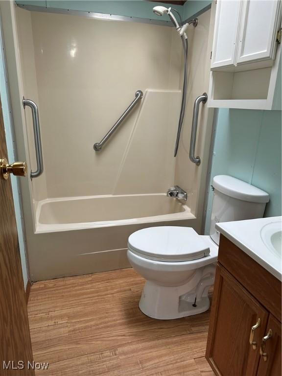 full bathroom with toilet, shower / bath combination, wood-type flooring, and vanity