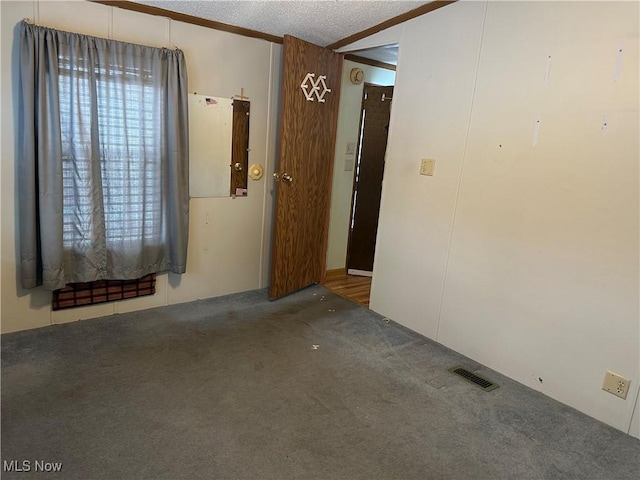 carpeted spare room with a textured ceiling