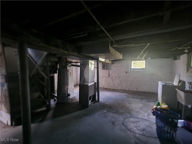 basement featuring washer and dryer, heating unit, and water heater