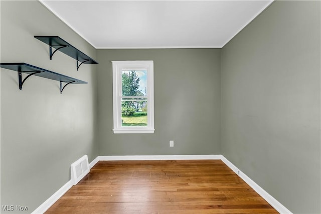 unfurnished room featuring hardwood / wood-style flooring and ornamental molding