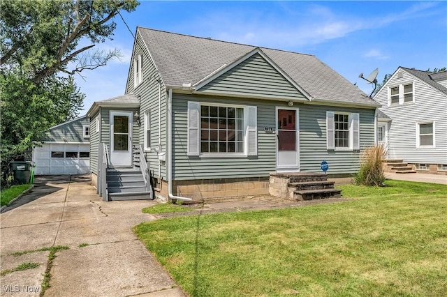 view of front facade featuring an outbuilding, a front yard, and a garage