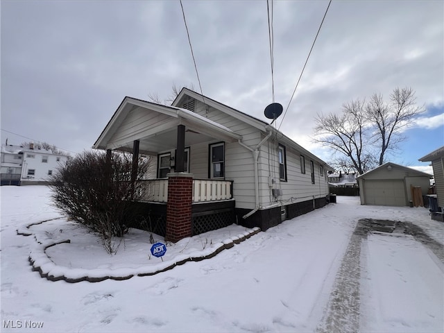 view of front of home featuring covered porch, a garage, and an outdoor structure